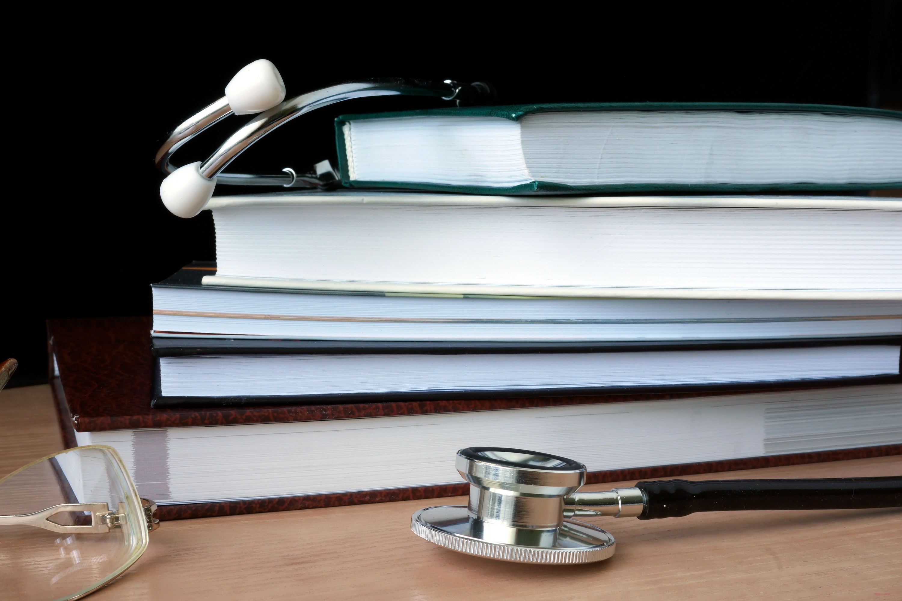 Close up of stethoscope resting on textbooks