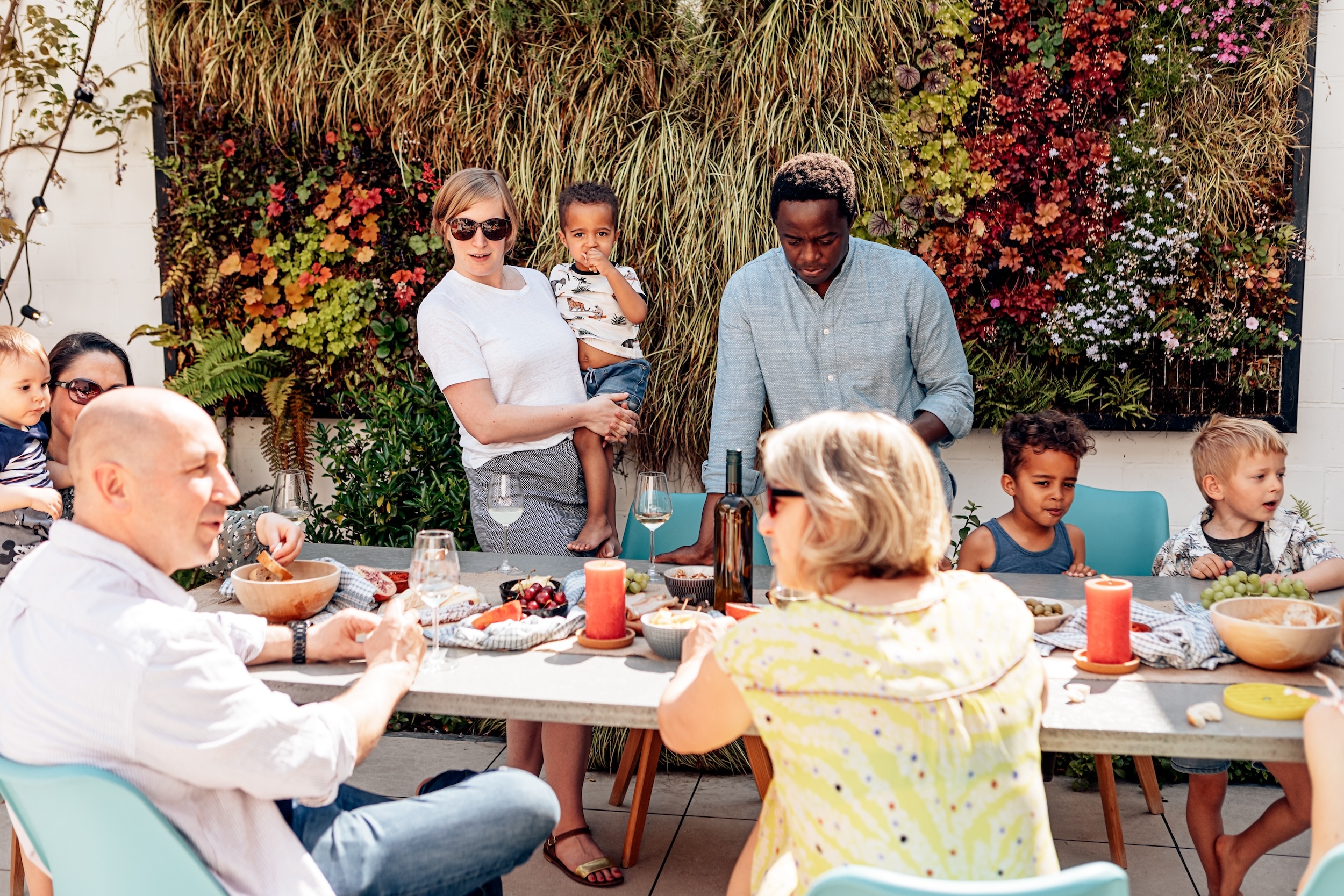 Happy family with kids gathered at outdoor dining table