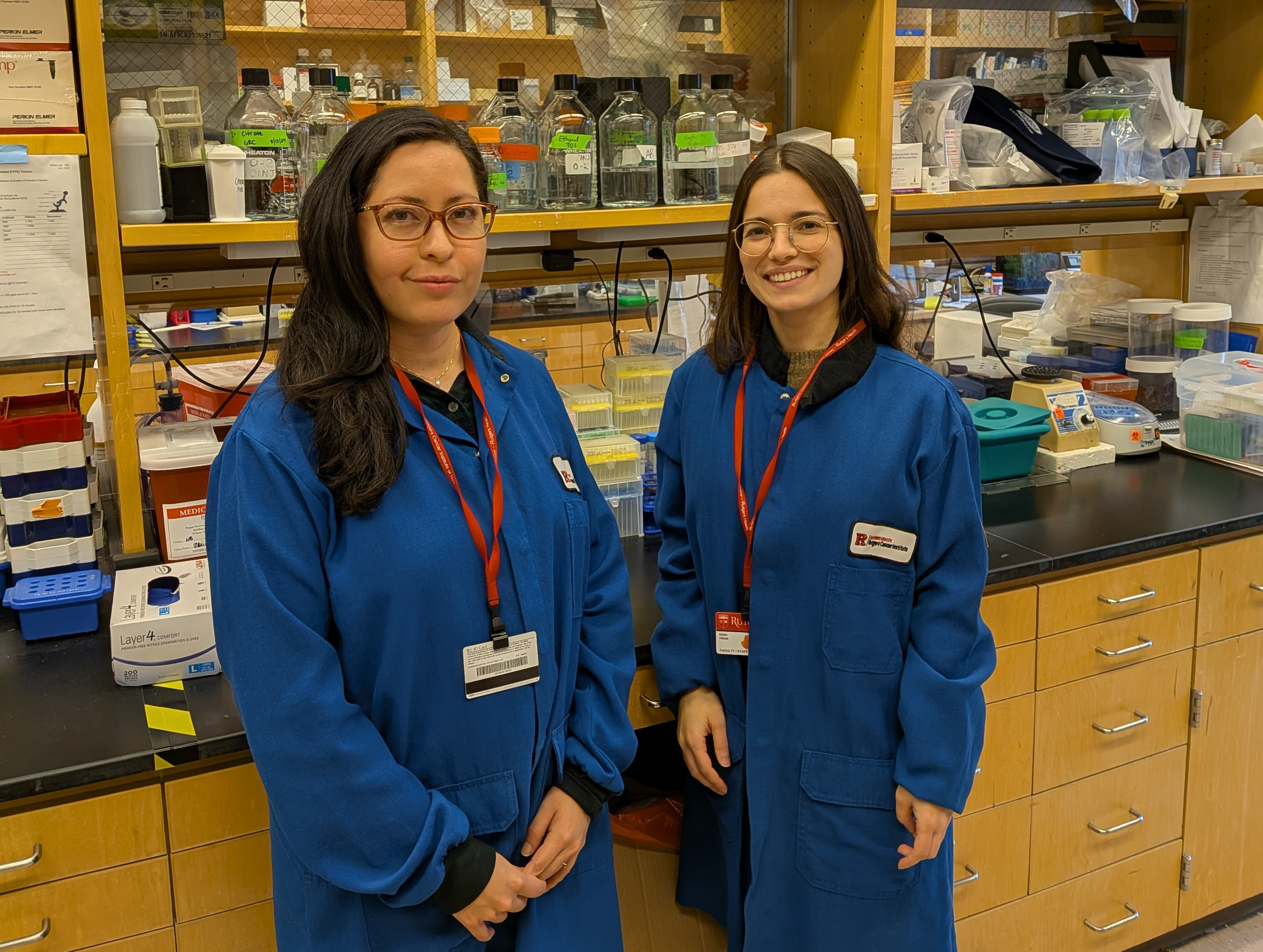 4 Research Scientists Standing in front of champagne and cake on folding table to celebrate doctorate degree