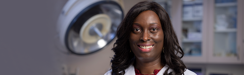 Dr. Omene standing in a surgical operating room