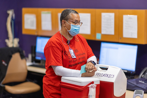 nurse standing at table with cooler