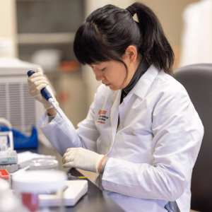 woman sitting and working at a laboratory bench