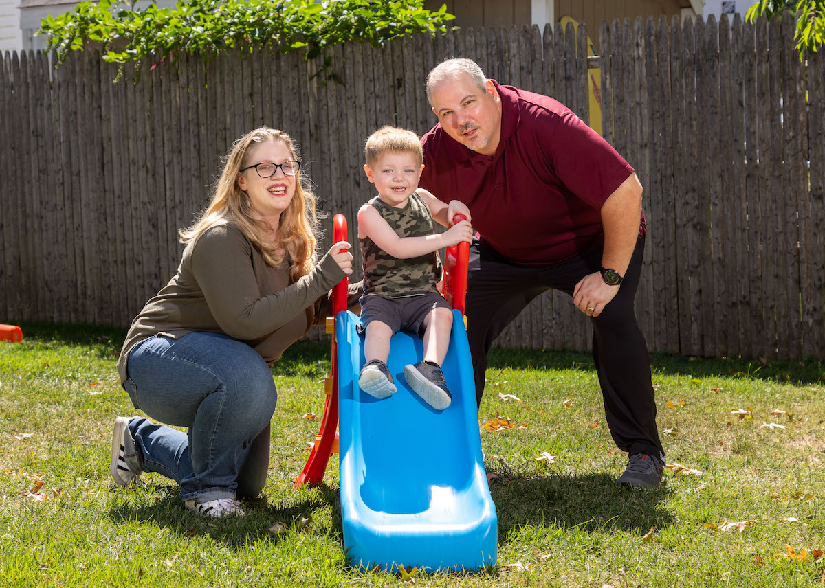 family playing outside on slide