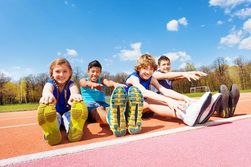 children stretching on a track