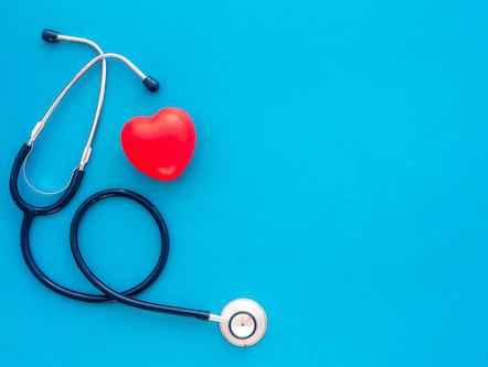 stethoscope and sculpture of a heart on a blue background
