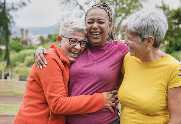 Happy multiracial senior women having fun together at park