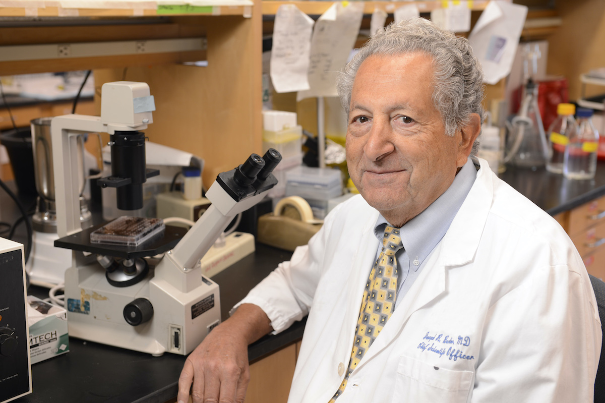 Dr. Bertino sitting at a laboratory bench