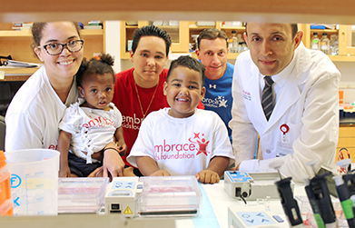 Dr. Peter Cole and Embrace Kids Foundation representatives and family members