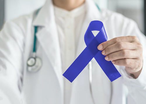picture of doctor in white coat holding blue colorectal cancer awareness ribbon