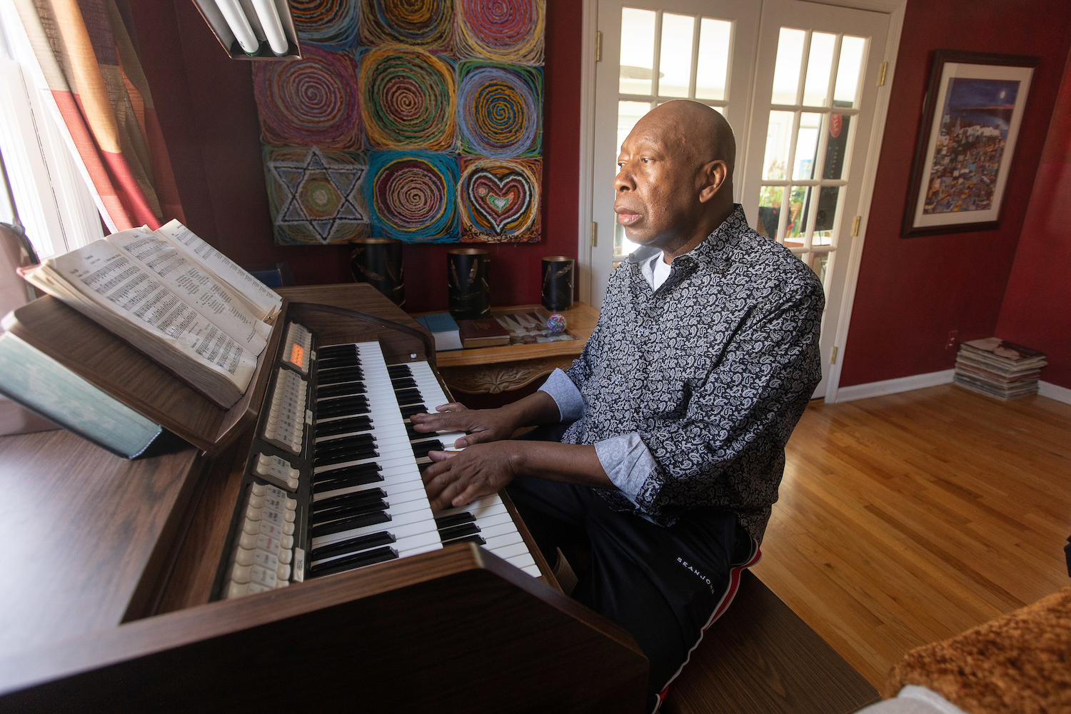 Dave Rodney playing piano in his home.