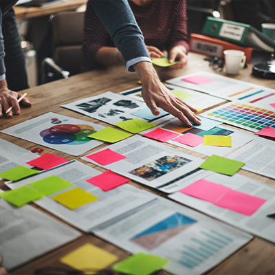 businessperson at a table covered in notes