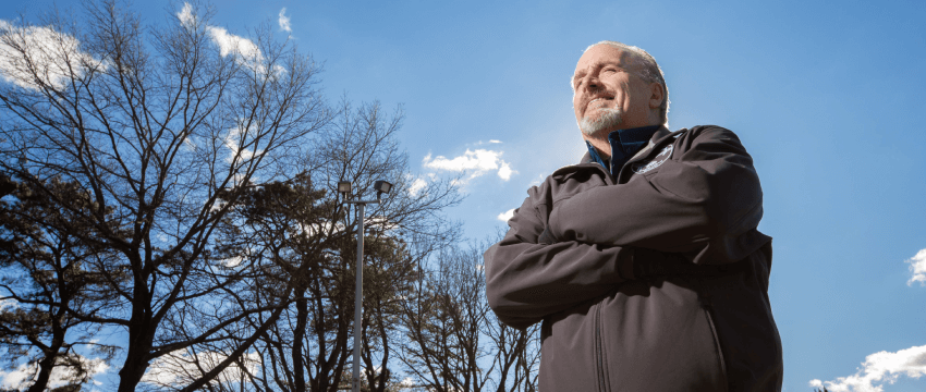 man standing against backdrop of a clear blue sky