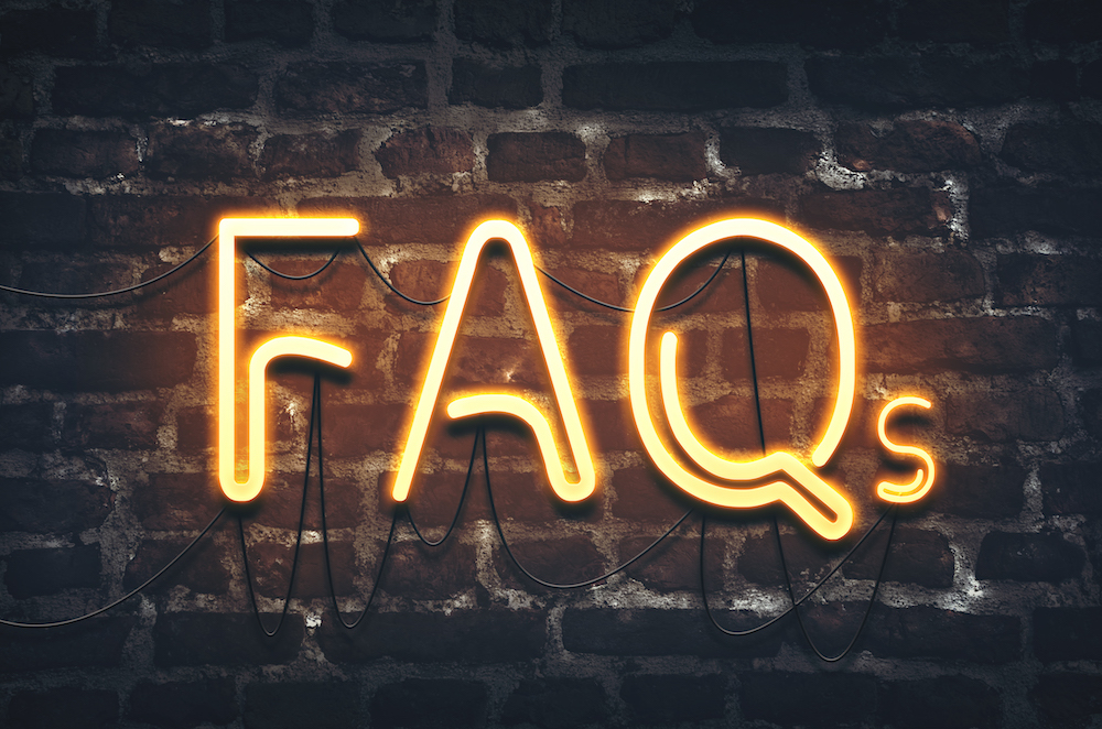 image of FAQs written in neon lights on a black brick wall