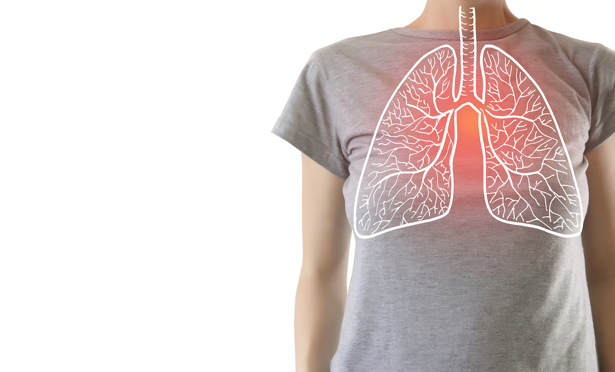 woman in a grey shirt standing against a white background with an illustration of lungs drawn over her torso