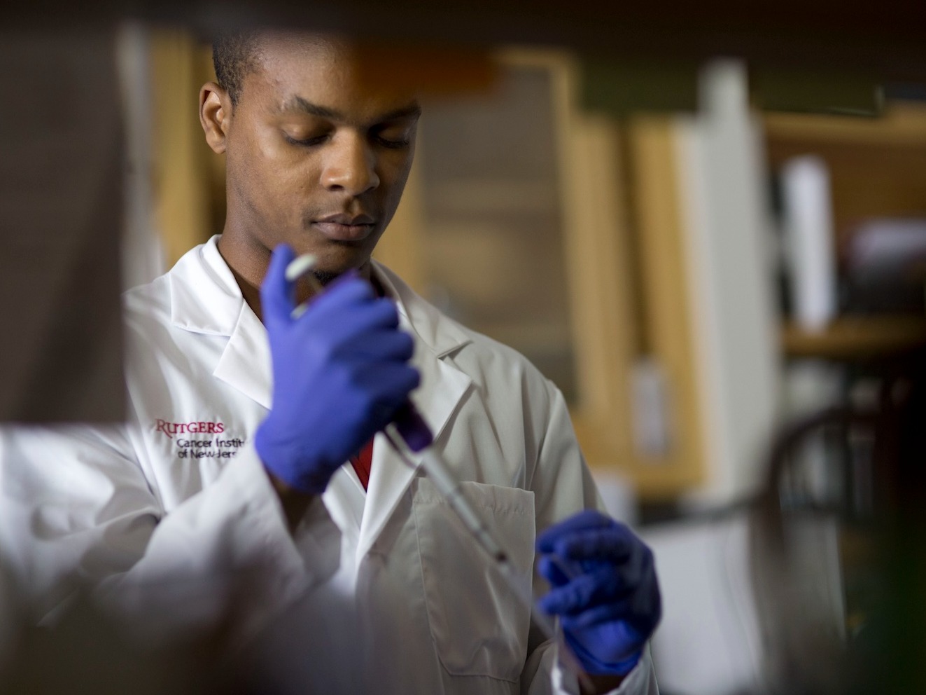 Researcher inserting fluid into vial