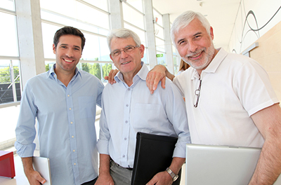 three men of varying ages standing in a hallway