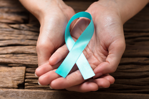 hands holding a teal ribbon